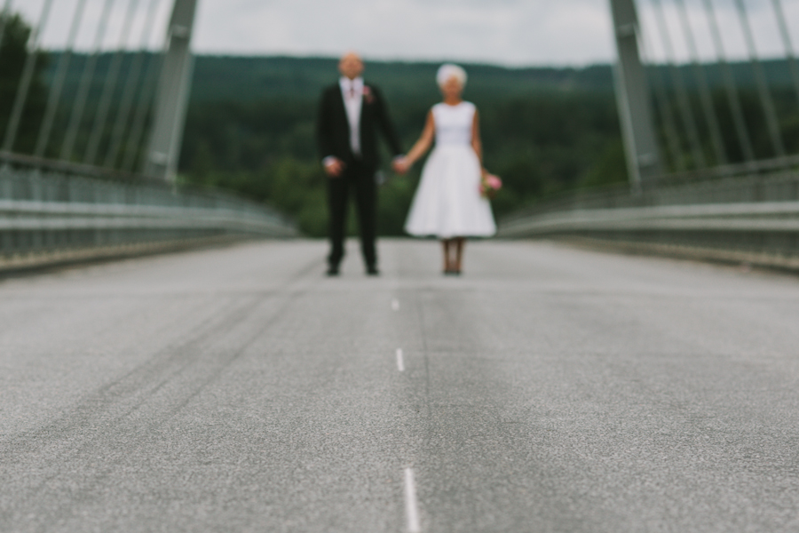 Bröllopsfotograf Hälsingland Brudparet står mitt på bron över Ljusnan
